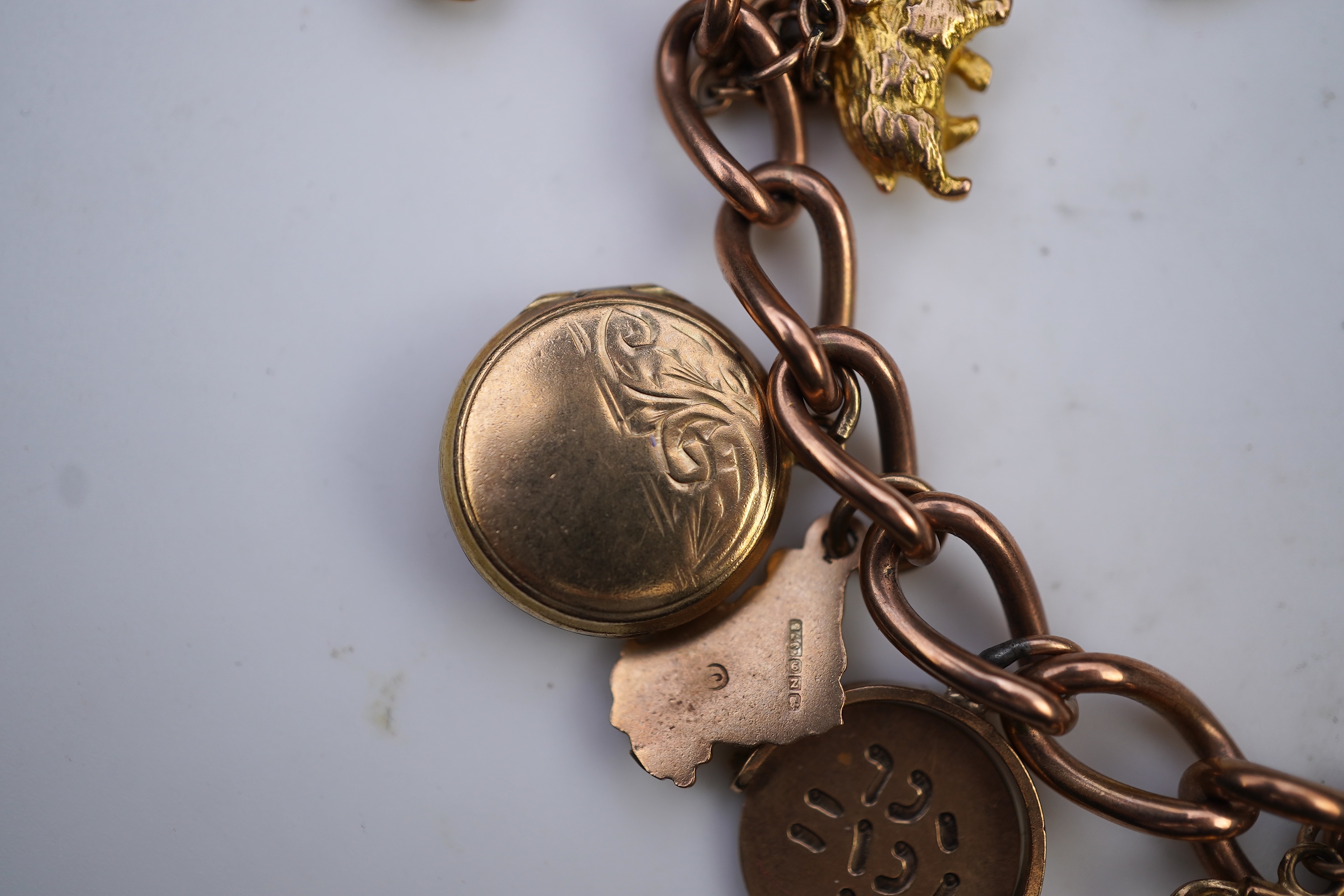 A gold charm bracelet, mid 20th century